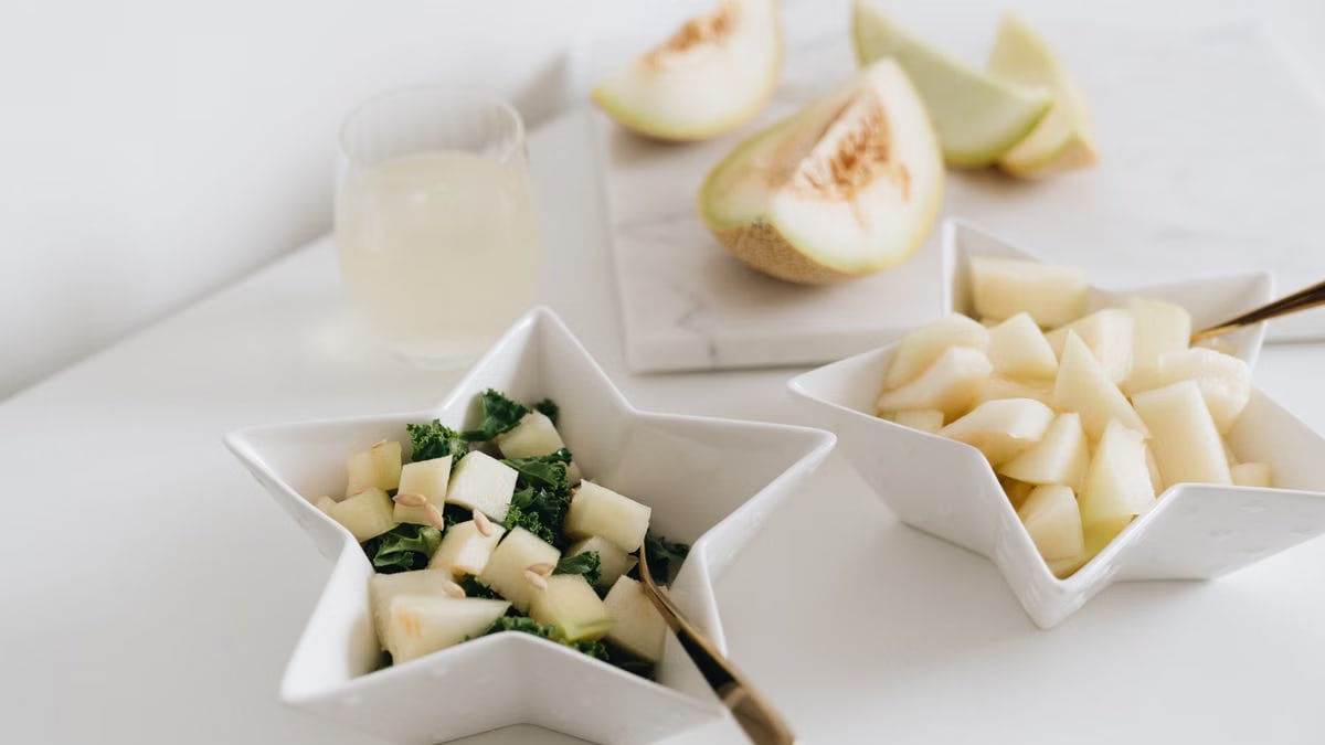 Delicious fresh melon salad served in stylish star-shaped bowls on a marble surface.